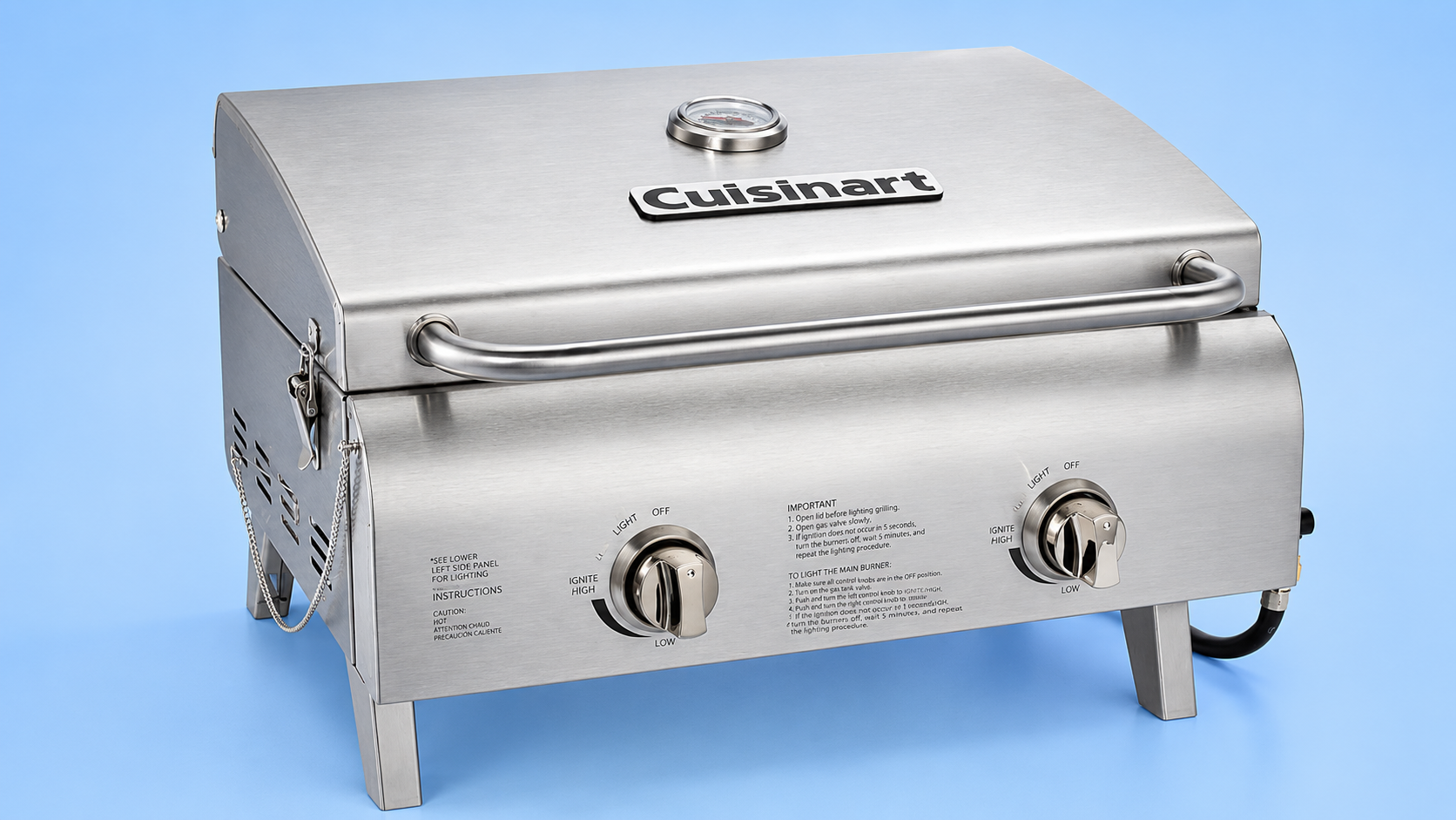 A Cuisinart portable stainless steel tabletop gas grill against a blue background.