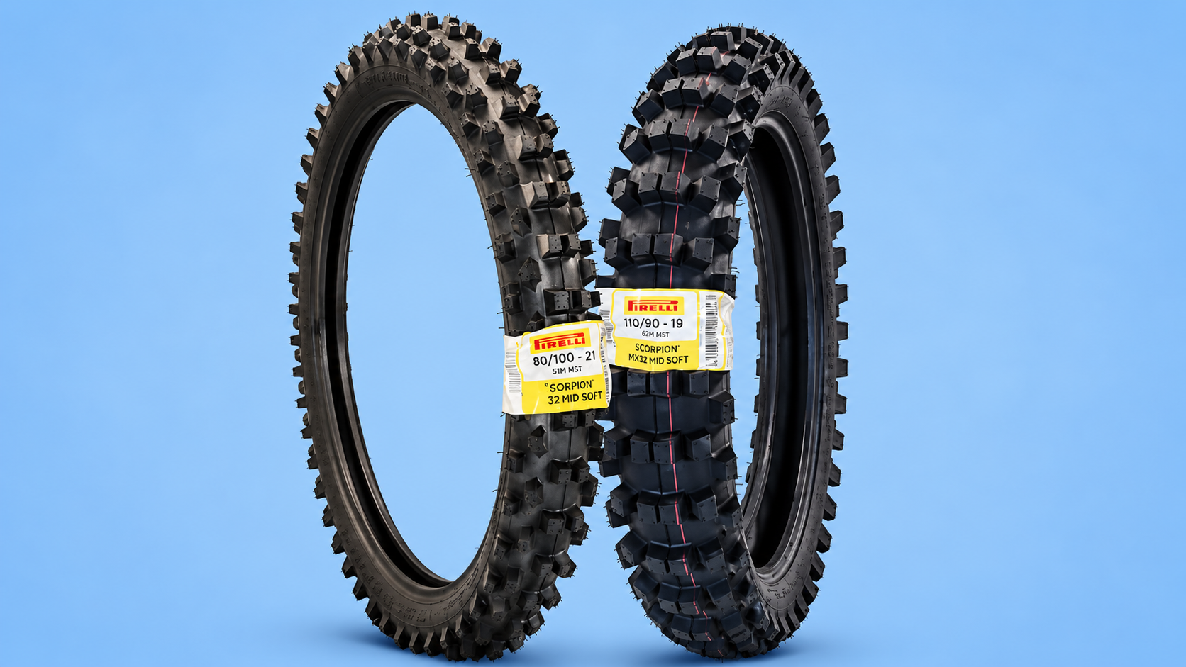 Two Pirelli Scorpion MX32 Mid Soft dirt bike tires with yellow labels against a blue background.