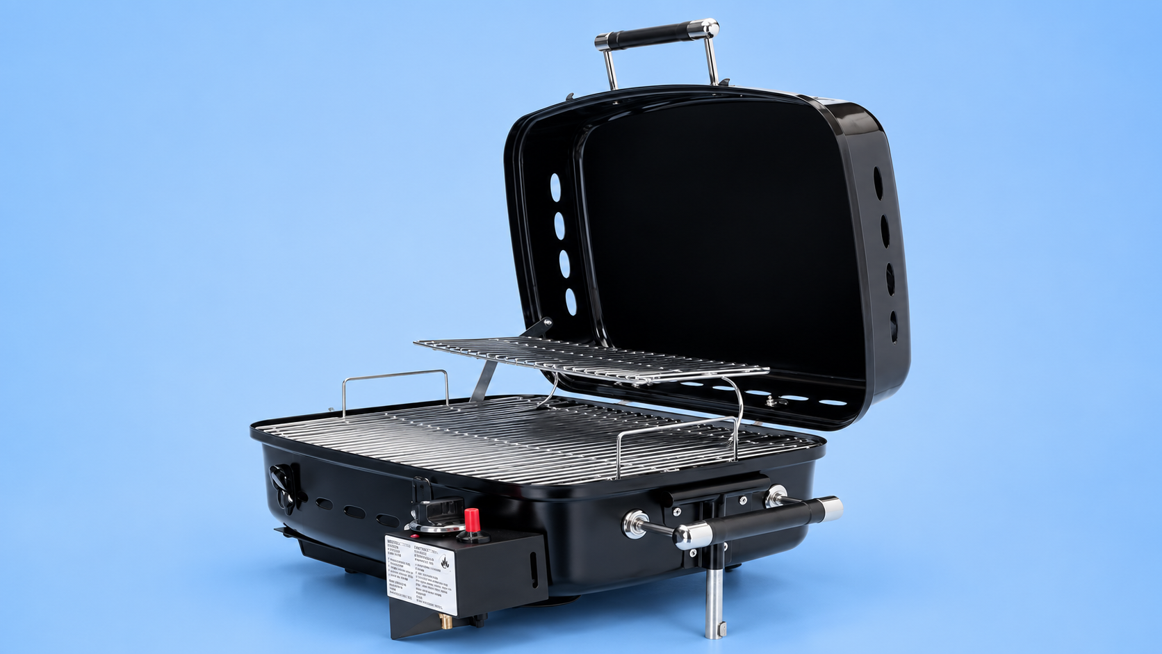 An open, portable black tabletop gas grill showing the internal cooking grates and a warming rack against a blue background.